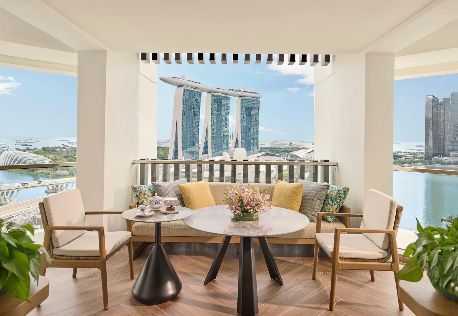 The balcony of the Royal Marina Bay Penthouse: a sofa and armchairs round a table, with Marina Bay Sands and the bay straight ahead.