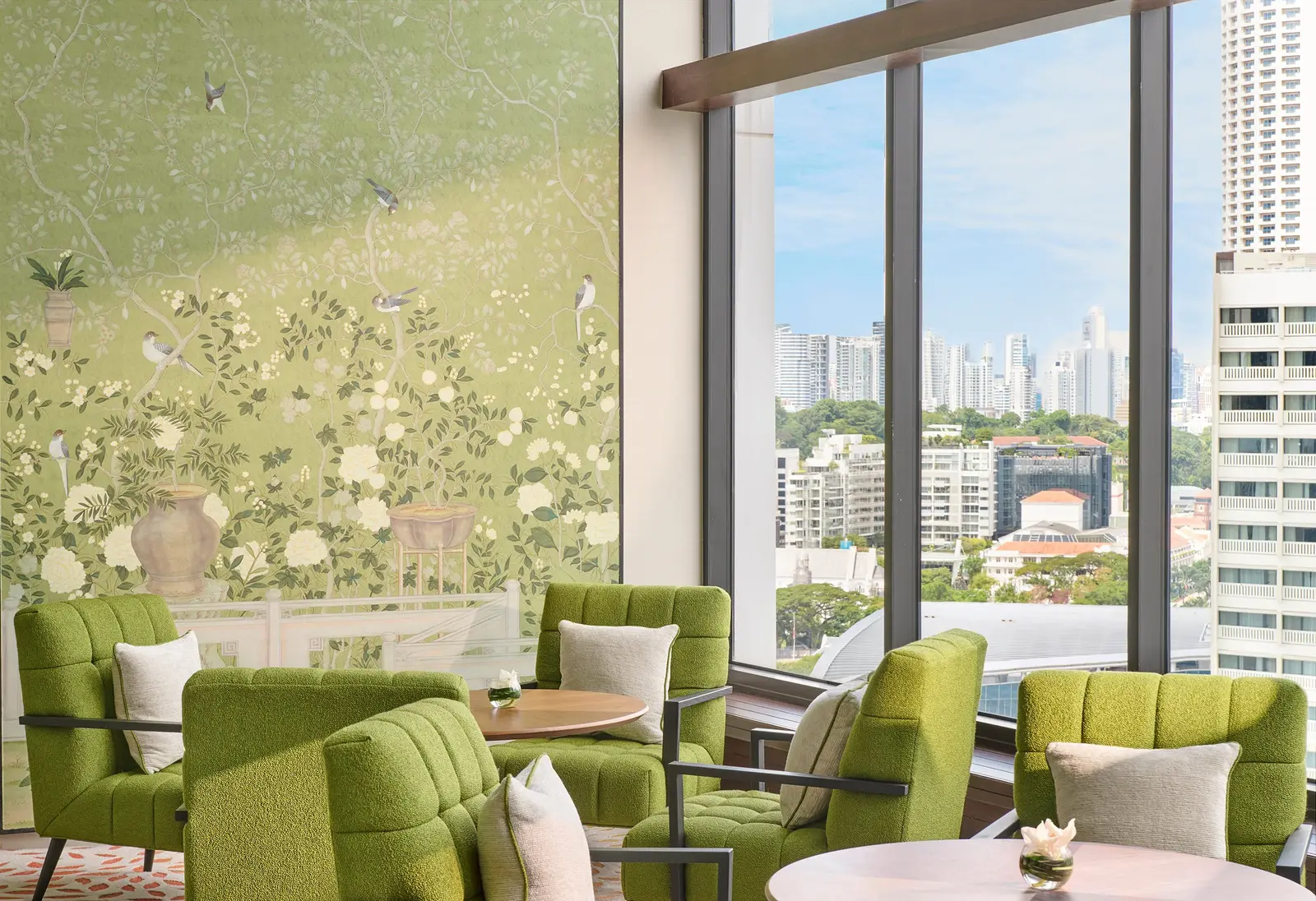 The HAUS 65 lounge that comes with the Club Marina Bay Room: green armchairs by the window and the flower-painted wall.