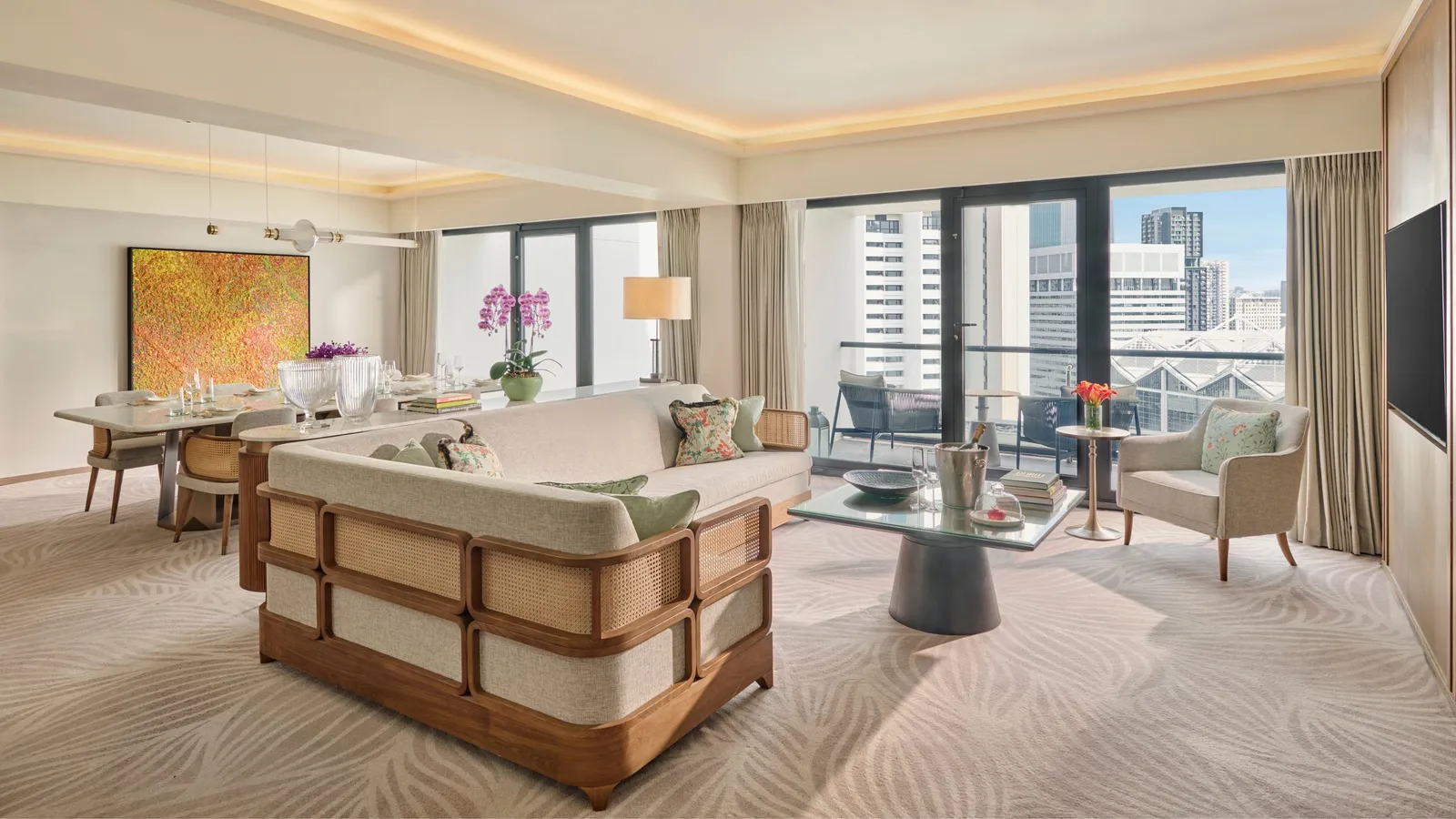 The living room of the Four Bedroom Residential Suite: the rattan sofa, the dining table and glazed doors to the balcony.