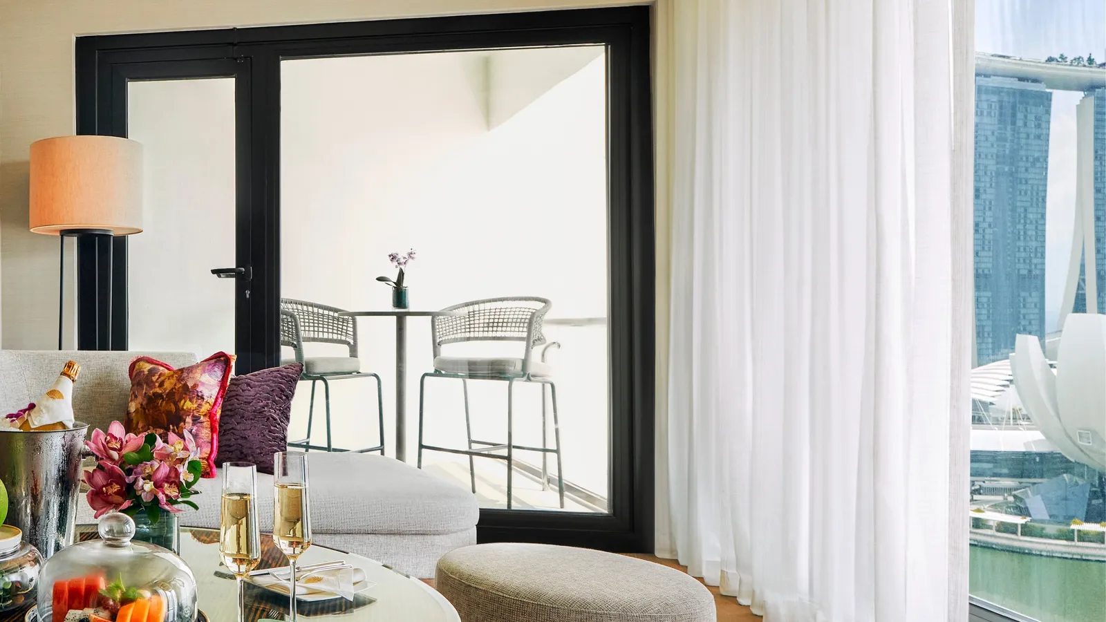 The balcony of the Marina Bay Suite with Balcony seen from the living room: 2 stools and a small table, with Marina Bay Sands beyond the rail.