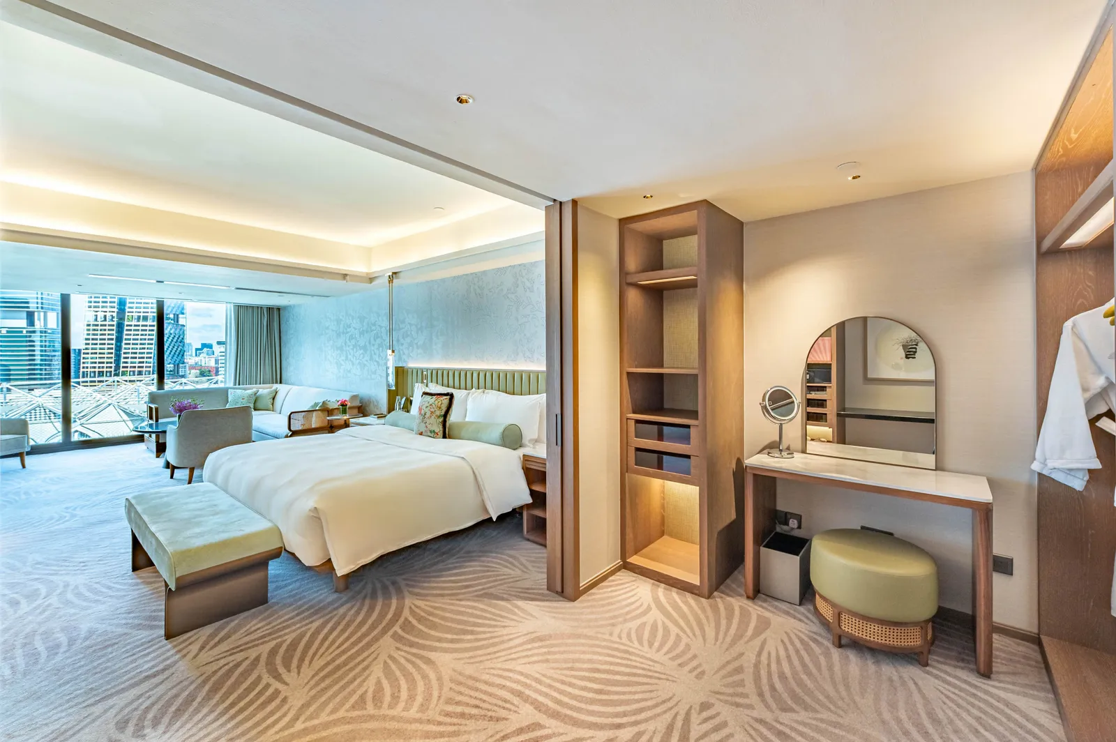 The bedroom of the Premier Family Suite: the bed by the window and a dressing table with an arched mirror.
