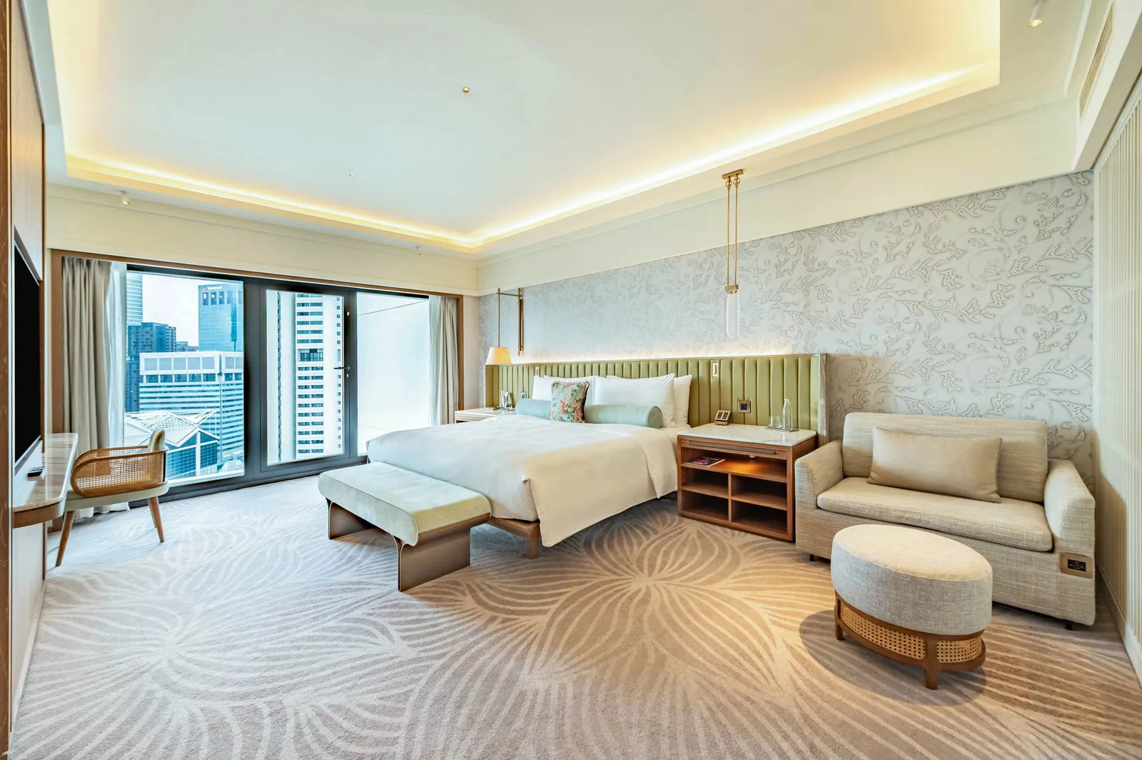 The bedroom of the Premier Family Suite with Balcony: the bed, a small sofa and glazed doors to the balcony.