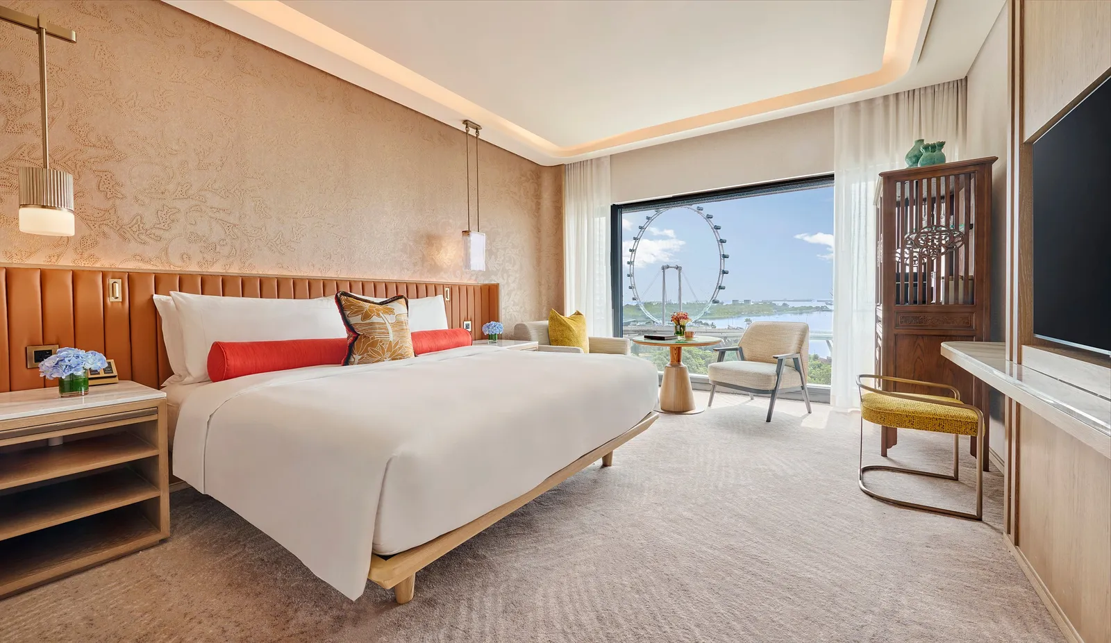 The Sea View Room: the bed with its tan headboard and, in the window, the Singapore Flyer wheel and the sea.