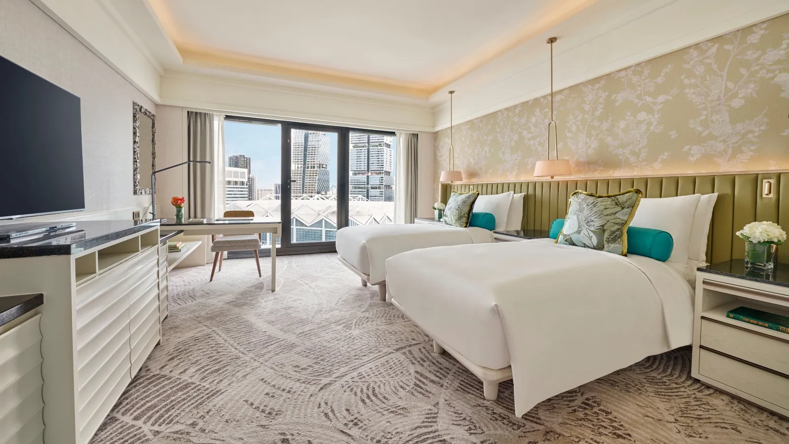 The connecting bedroom of the Two Bedroom Residential Suite: twin beds with a green headboard and the glazed door to the balcony.