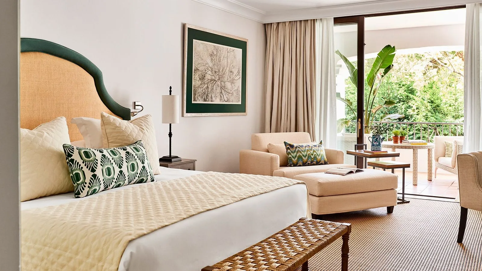 Bed, sofa and terrace in a Deluxe Room
