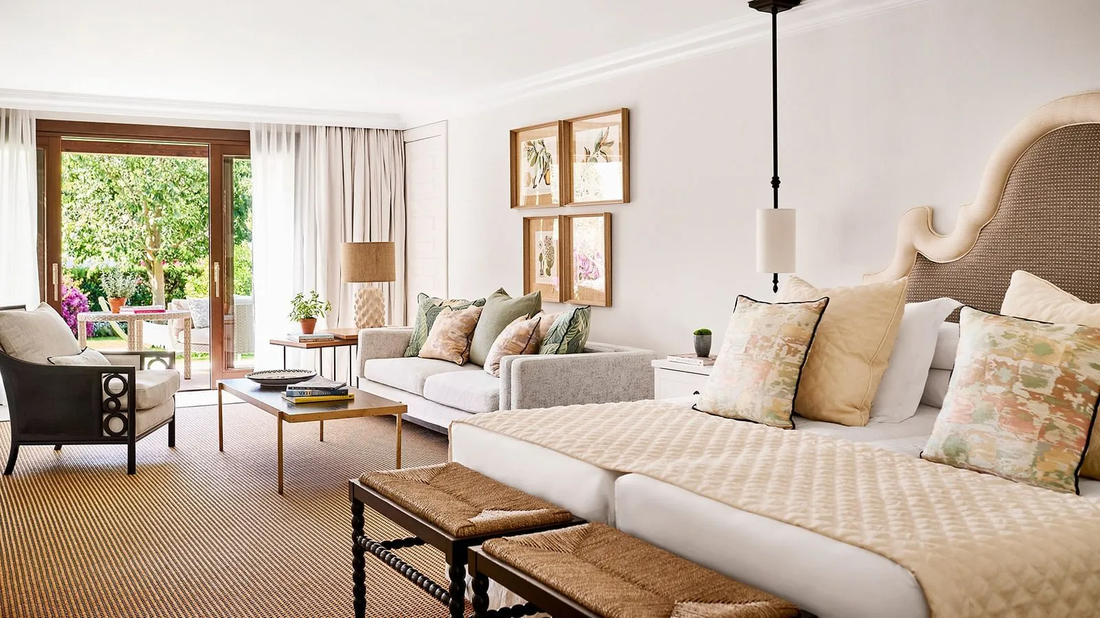 Bed, sofa and doors towards the garden in a Junior Suite Deluxe