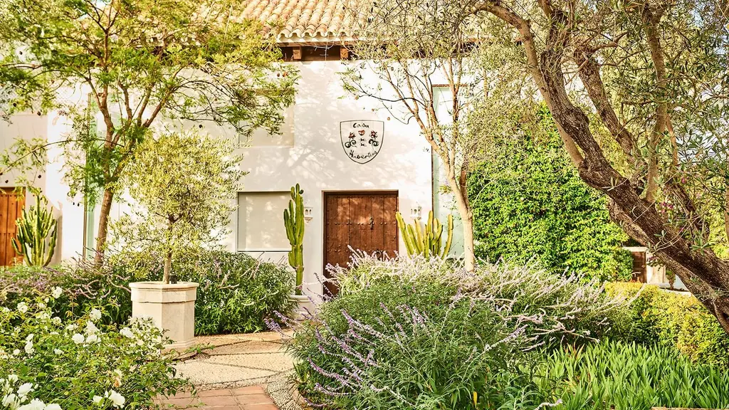 Entrance to Casa Hubertus among plants and flowers