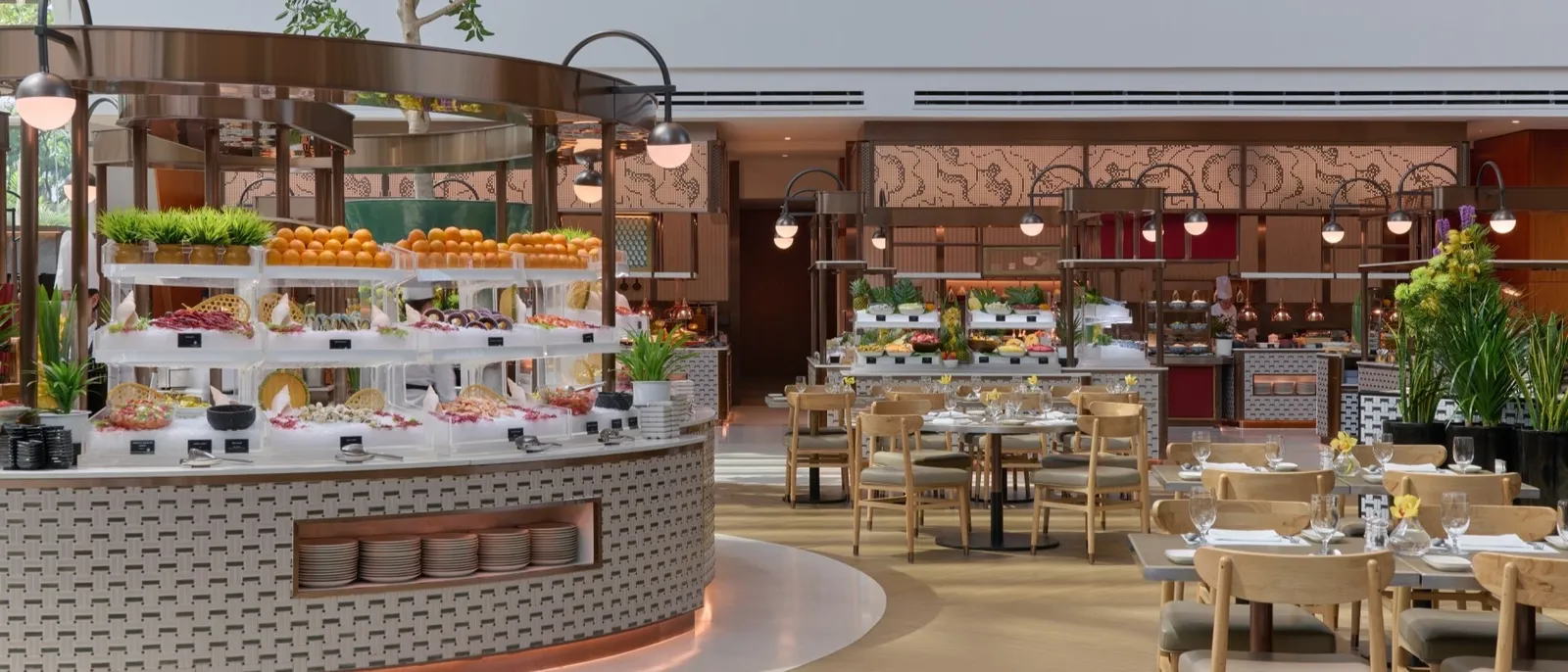 The dining room at RISE: the buffet islands with rows of fruit, and the laid tables.