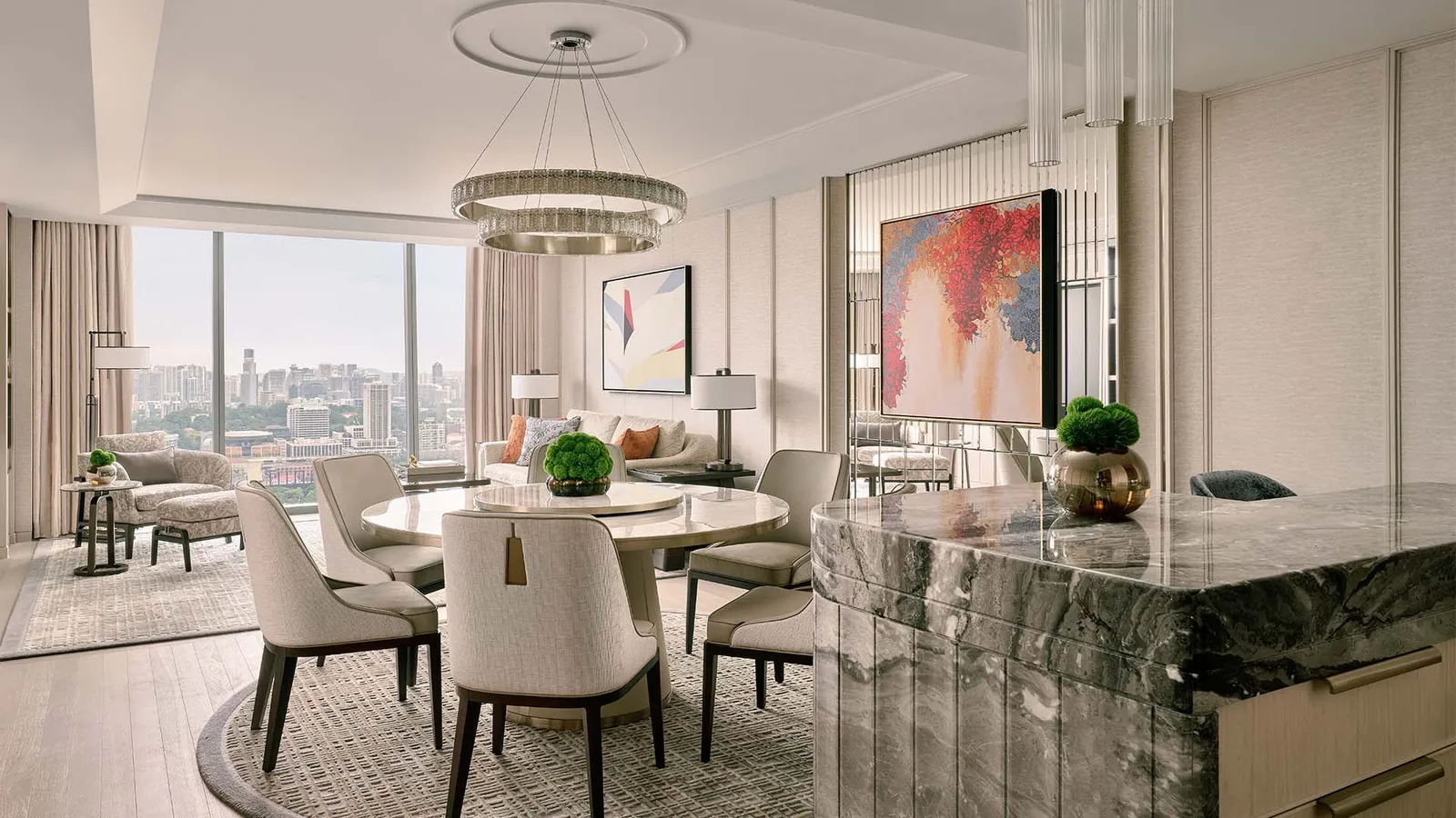 Paiza Premier Suite: the round dining table under the chandelier, the sitting area and the city through the window.