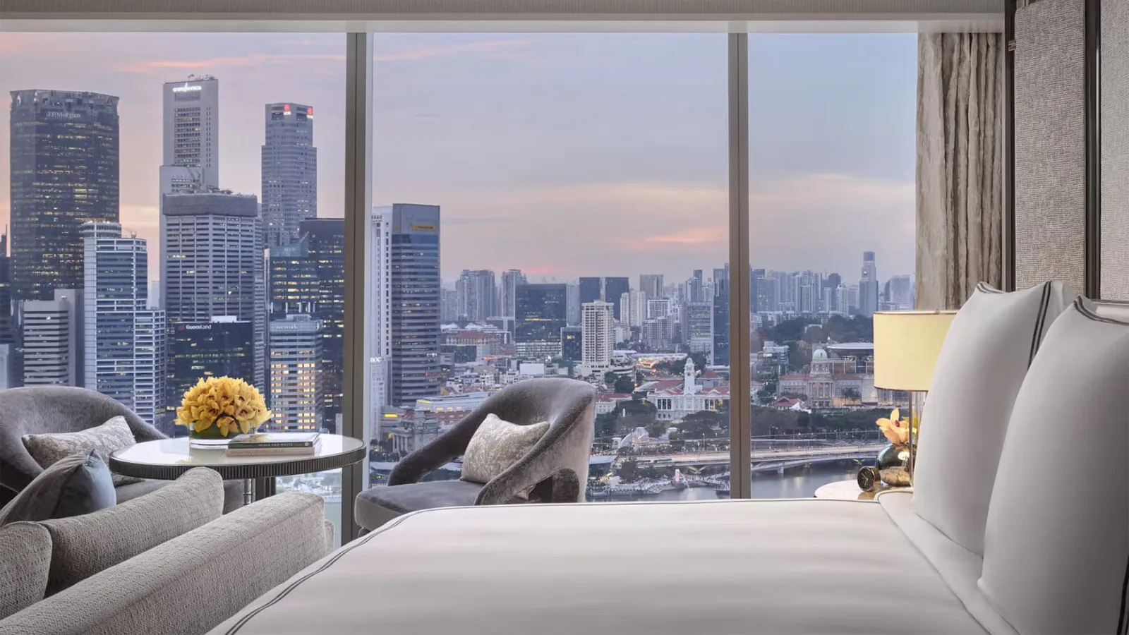Sands Premier Studio: the bed and 2 armchairs facing the window on the downtown towers at dusk.