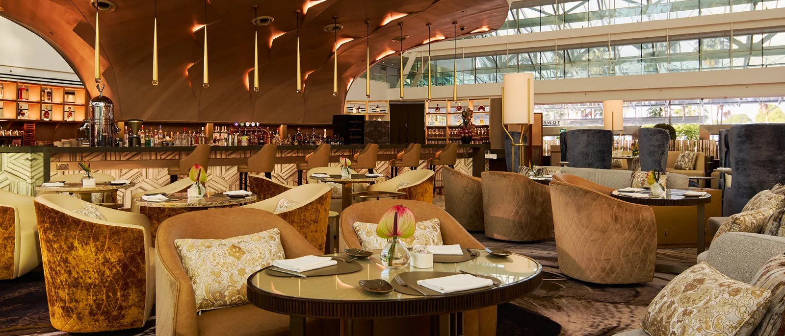 The sofas and tables of The Club under the slatted timber canopy of the lobby.