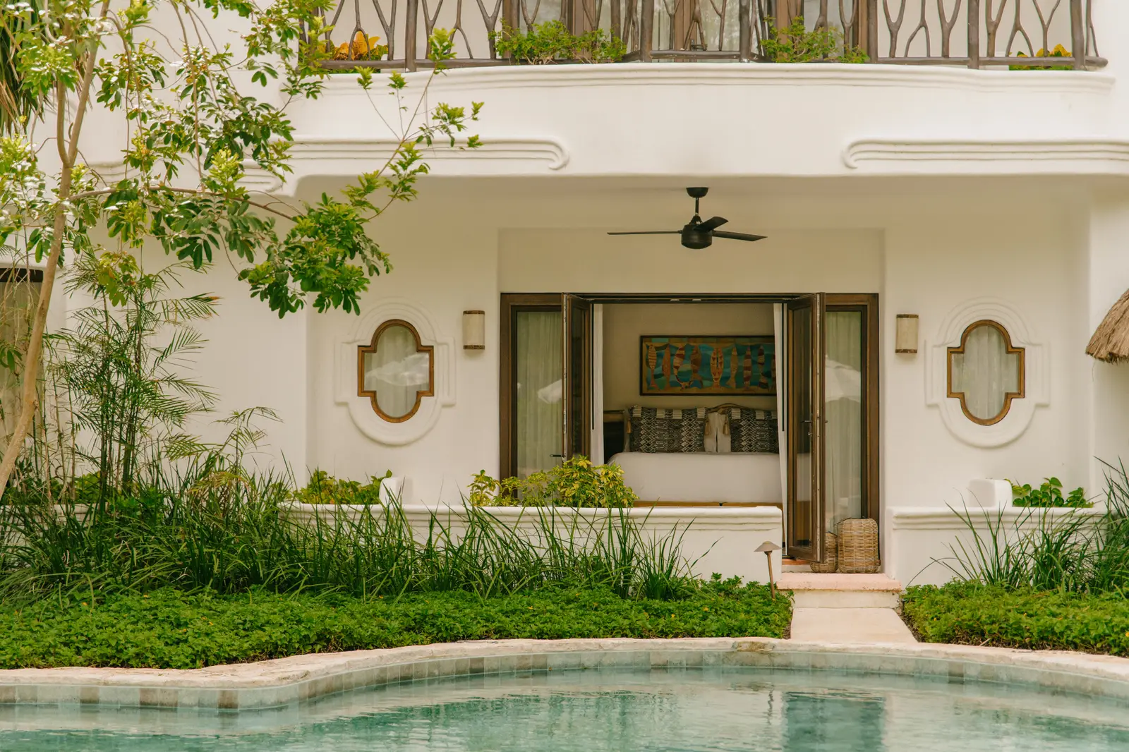 Le porte di una Deluxe Garden View Room si aprono sul verde e sulla piscina