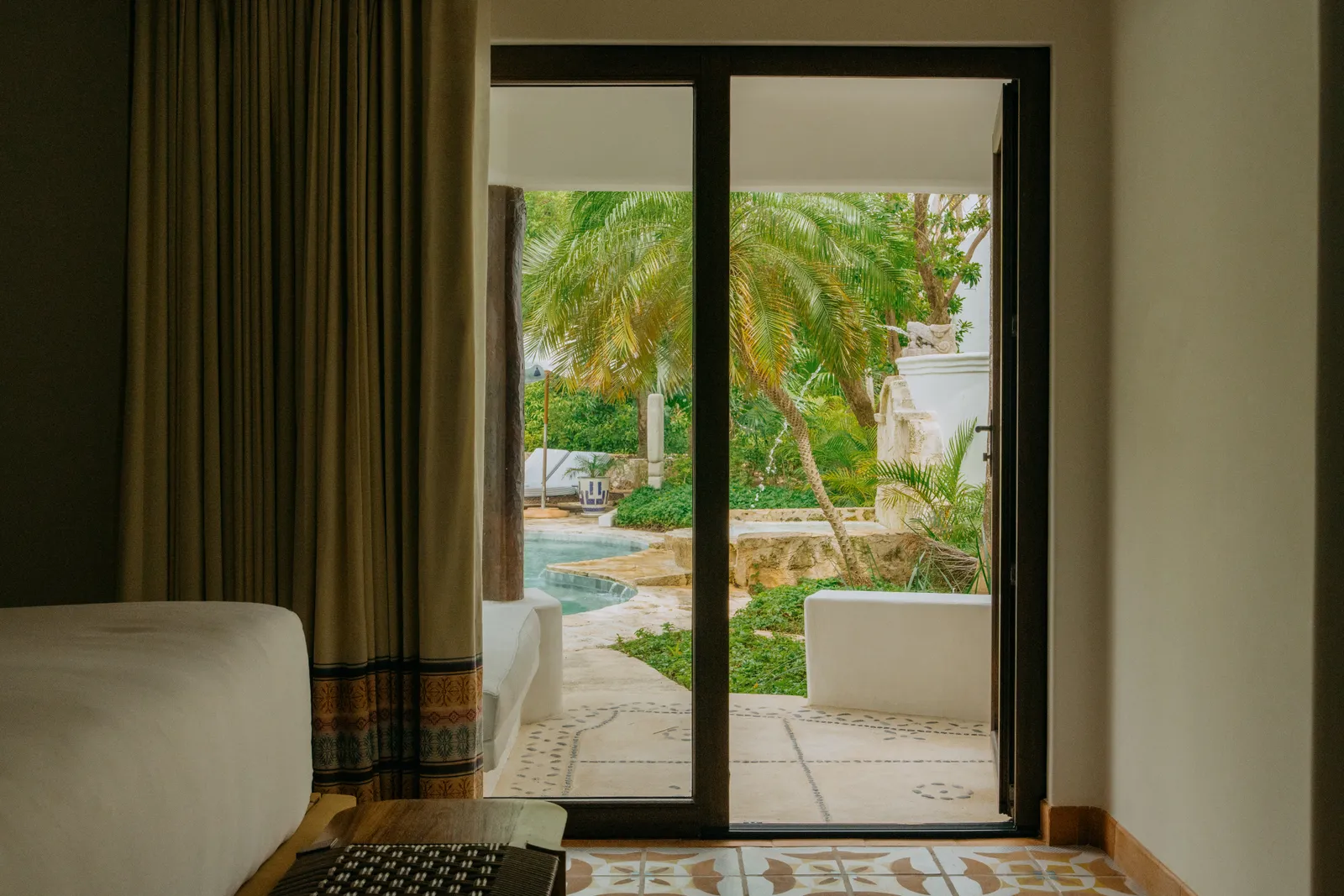 Dalla Garden View Junior Suite, la porta a vetri apre sul patio fra le piante
