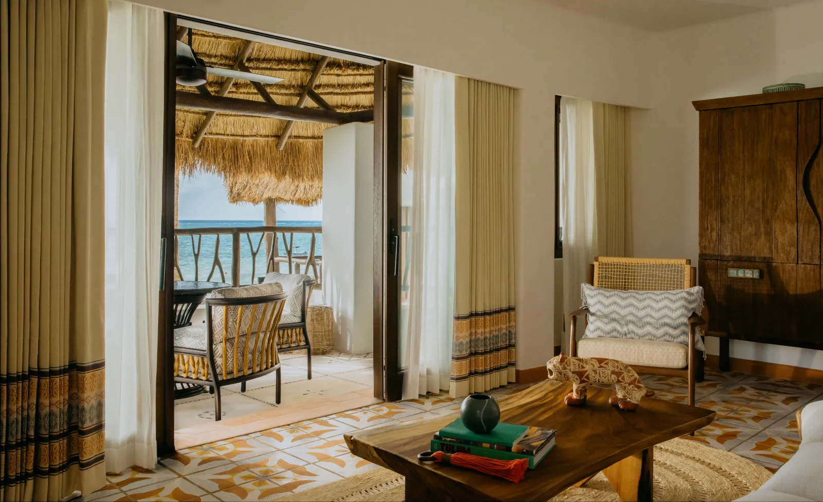 Il letto della Oceanfront One Bedroom Suite davanti alle porte aperte sulla terrazza verso il mare