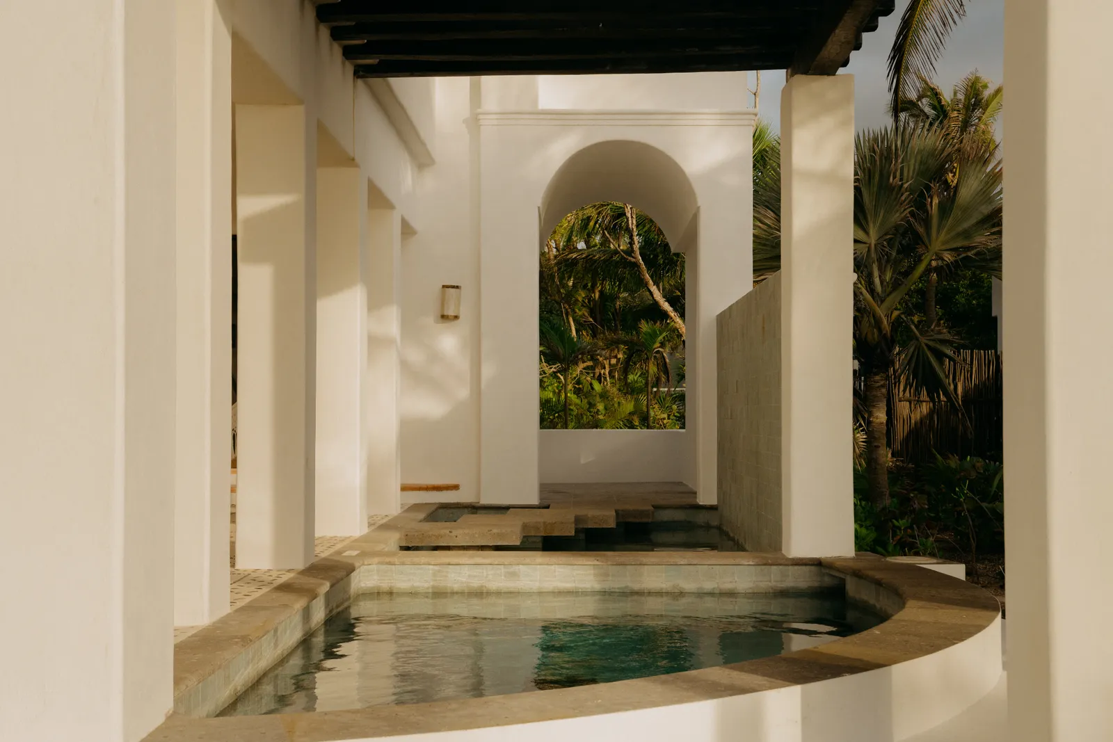 Il patio di una suite Oceanfront con 2 camere, una vasca di pietra e gli archi sul giardino
