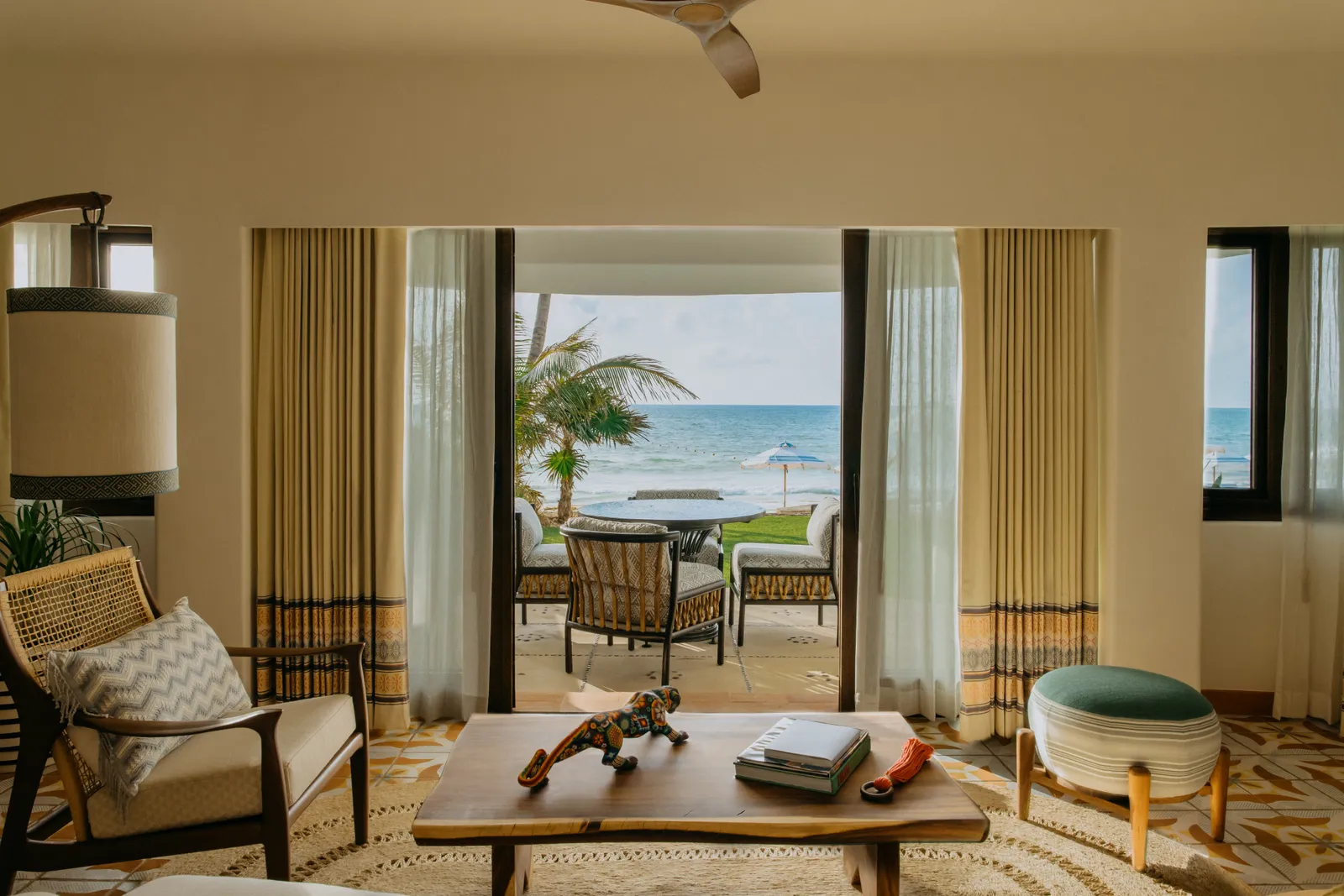Il soggiorno di Villa Maroma, con una poltrona davanti alle porte aperte sul mare