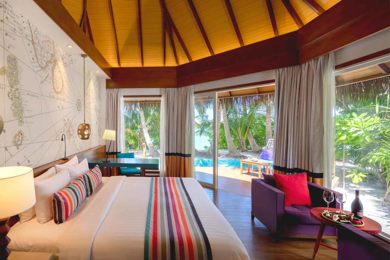 A Beach Pool Villa bedroom, its private pool visible beyond the glass doors.