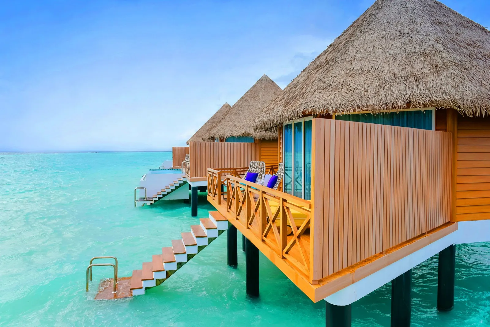 An Overwater Villa on stilts, with its deck and the steps down into the sea.