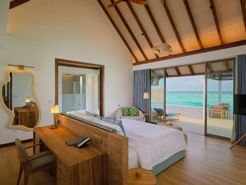 The bedroom with its bed and glass doors towards the sea.