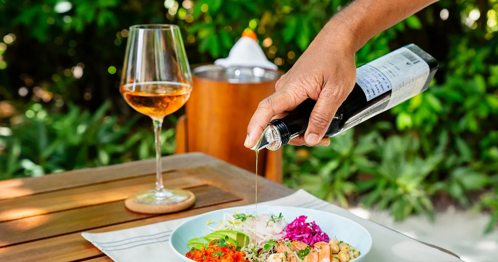 A glass of rosé poured at Azure, beside a salad