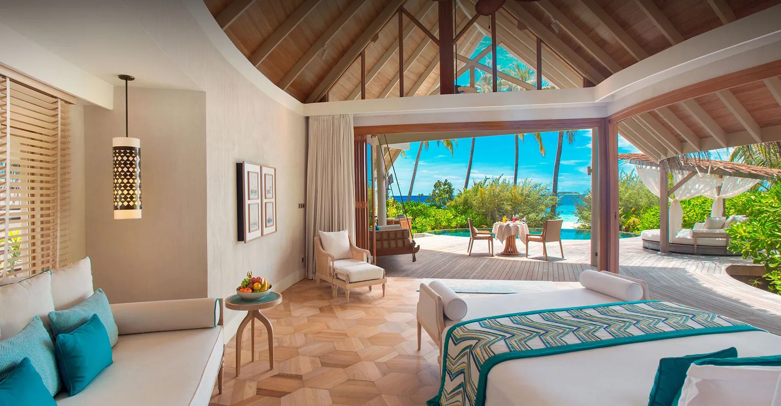 A Beach Pool Villa’s bedroom, the bed and the glass doors open onto the beach