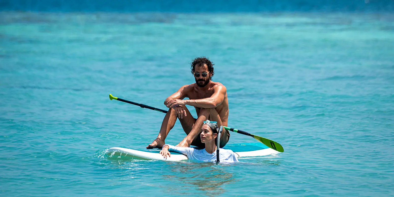 2 people on a paddleboard in the lagoon