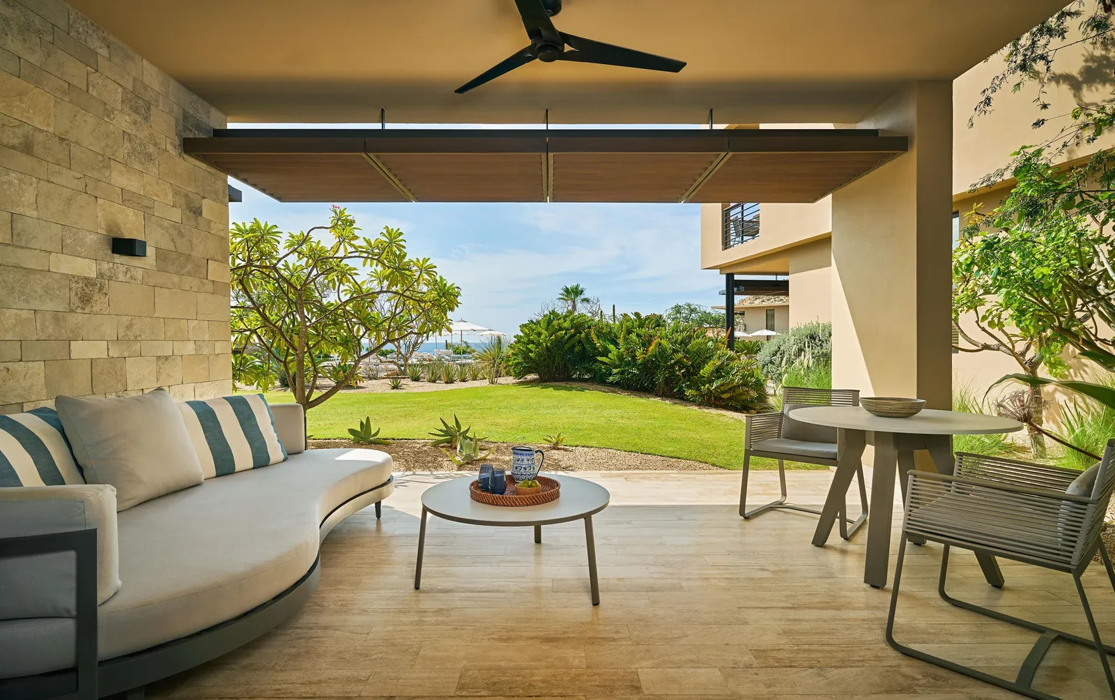 Il patio ombreggiato, con prato e uno scorcio di mare