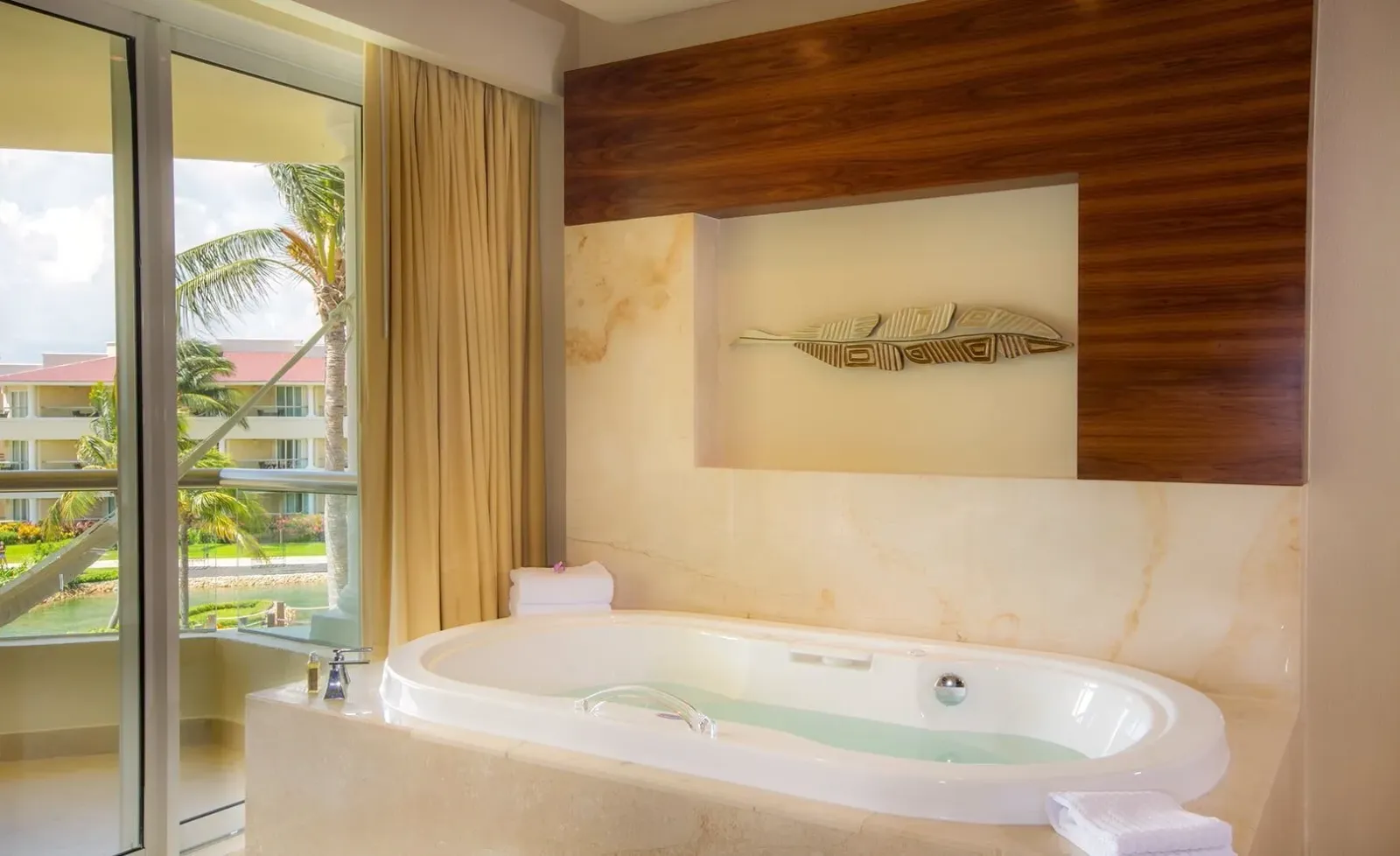The whirlpool bath beside the balcony door in a Superior Honeymoon Suite