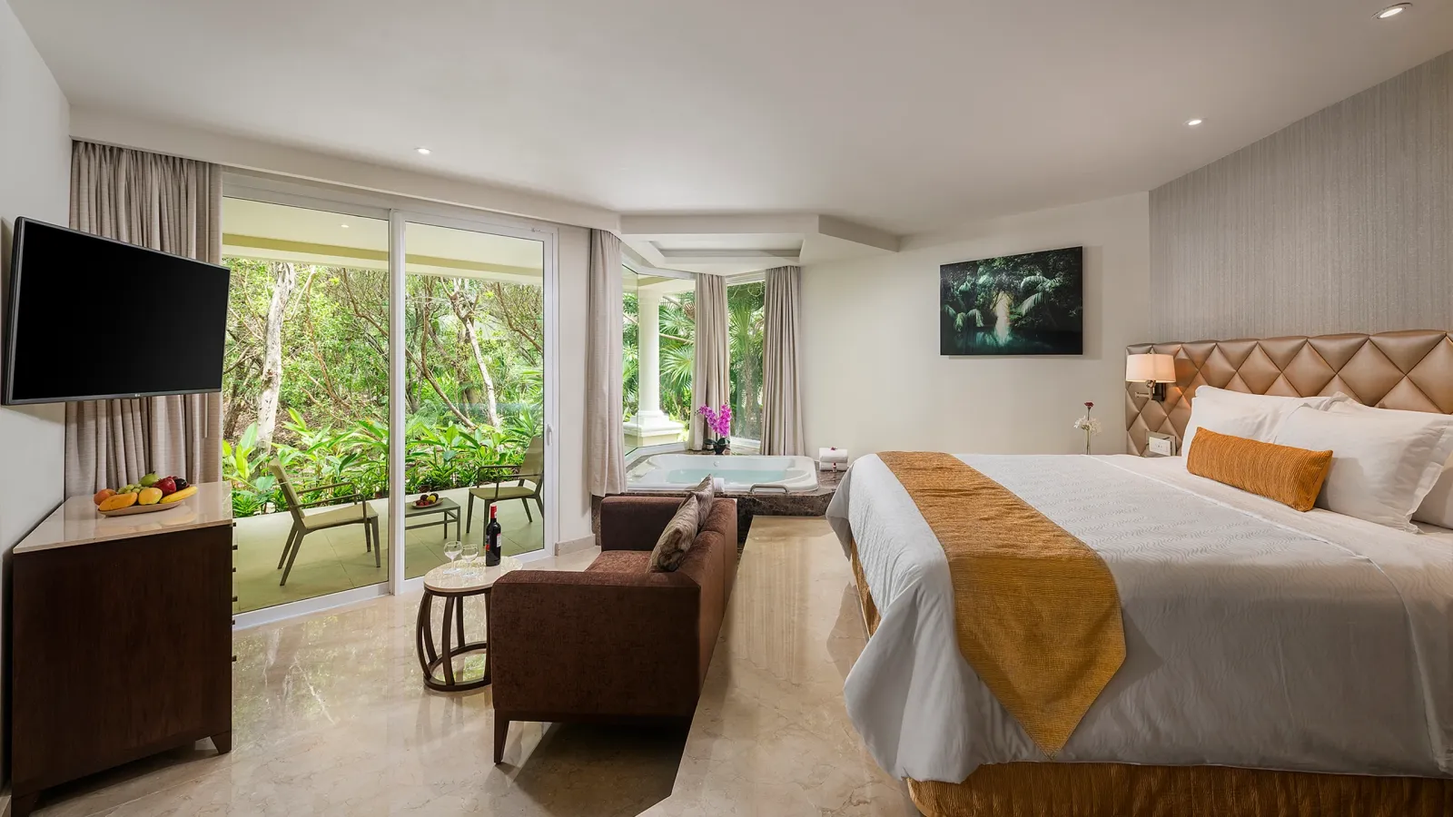 King bed, sofa and terrace facing greenery in a Junior Suite Golf Course View