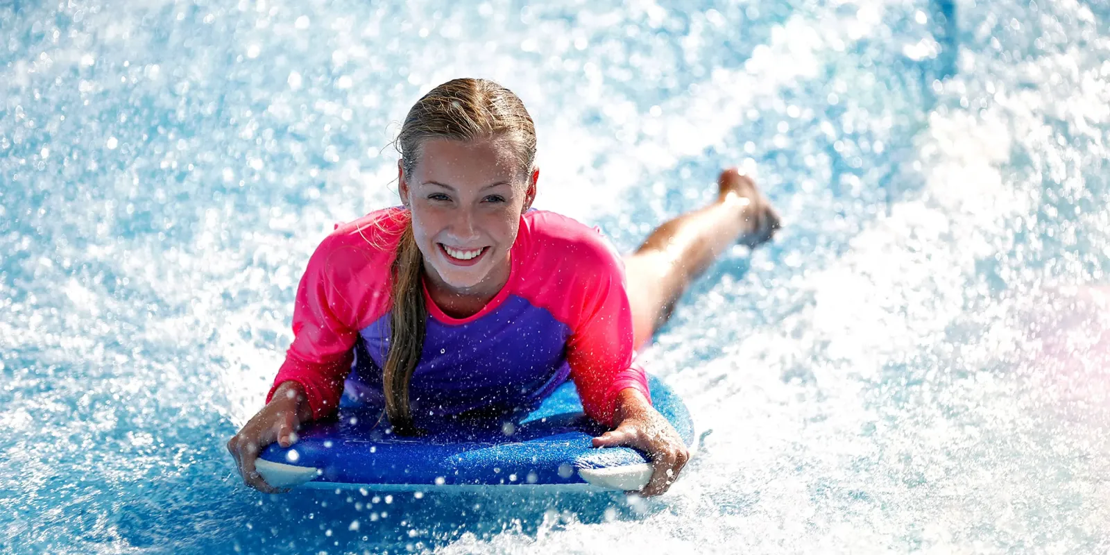 A child on a bodyboard in the FlowRider’s moving water