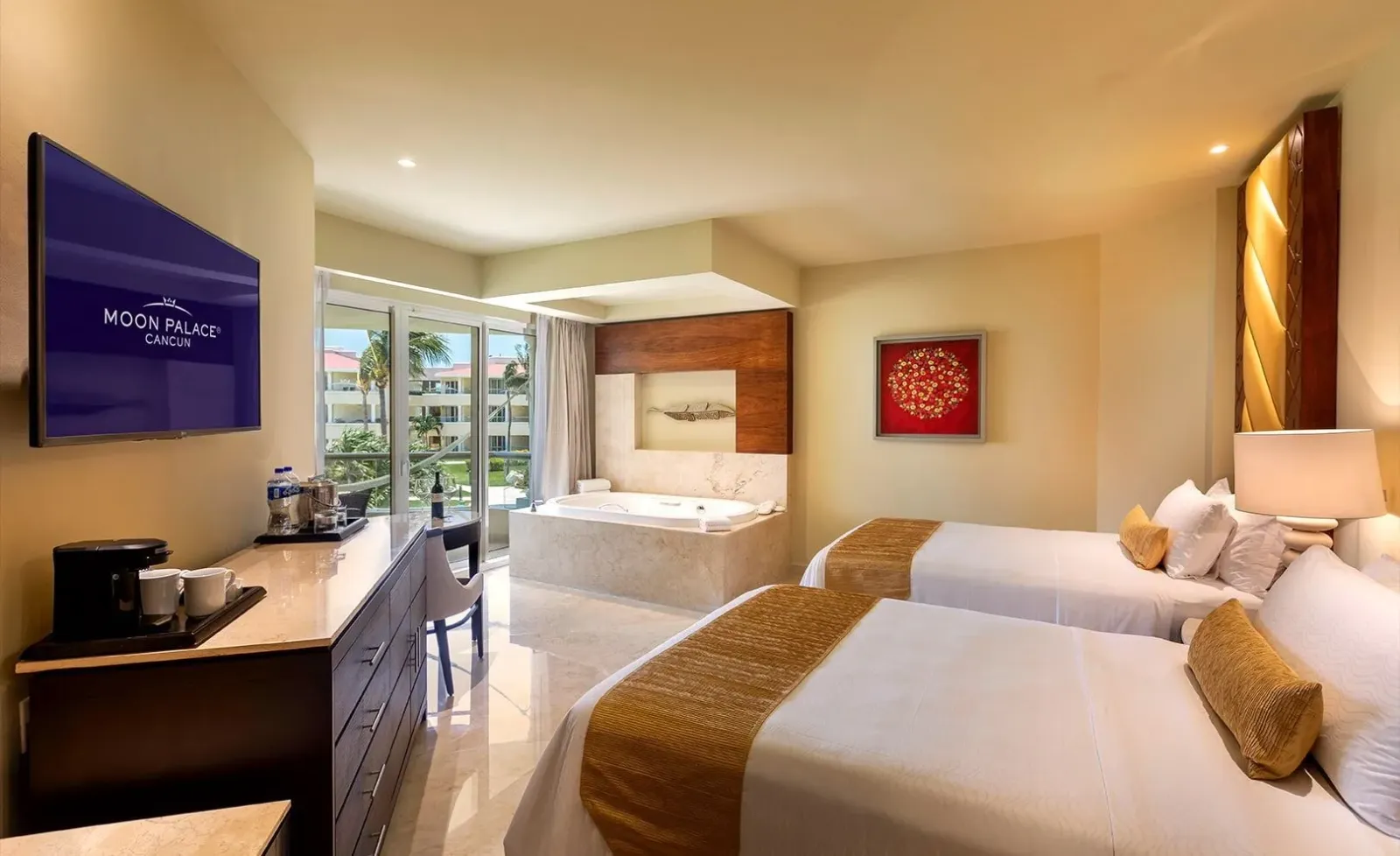 Beds, whirlpool bath and balcony door in a Superior Deluxe Garden View