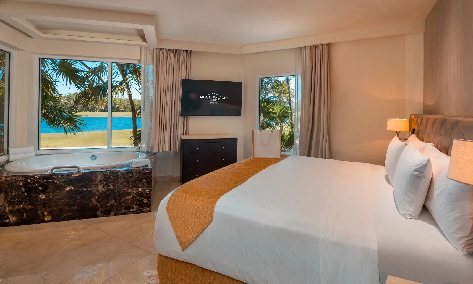 A bedroom in a Two Bedroom Suite Golf Course View, with greenery beyond the window