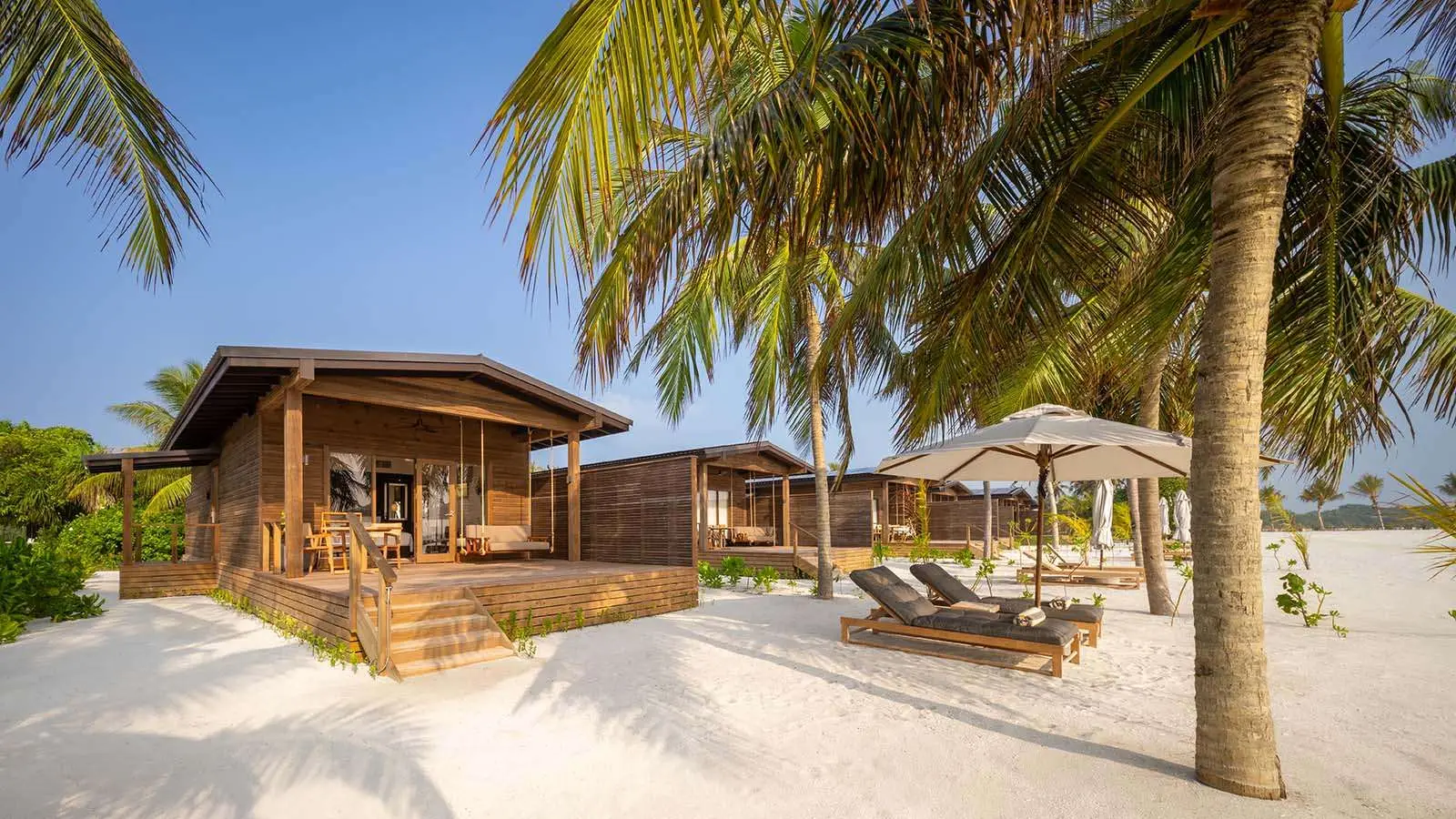 Una Romantic Beach Villa fra le palme: la veranda con l’altalena, i lettini e l’ombrellone sulla sabbia.
