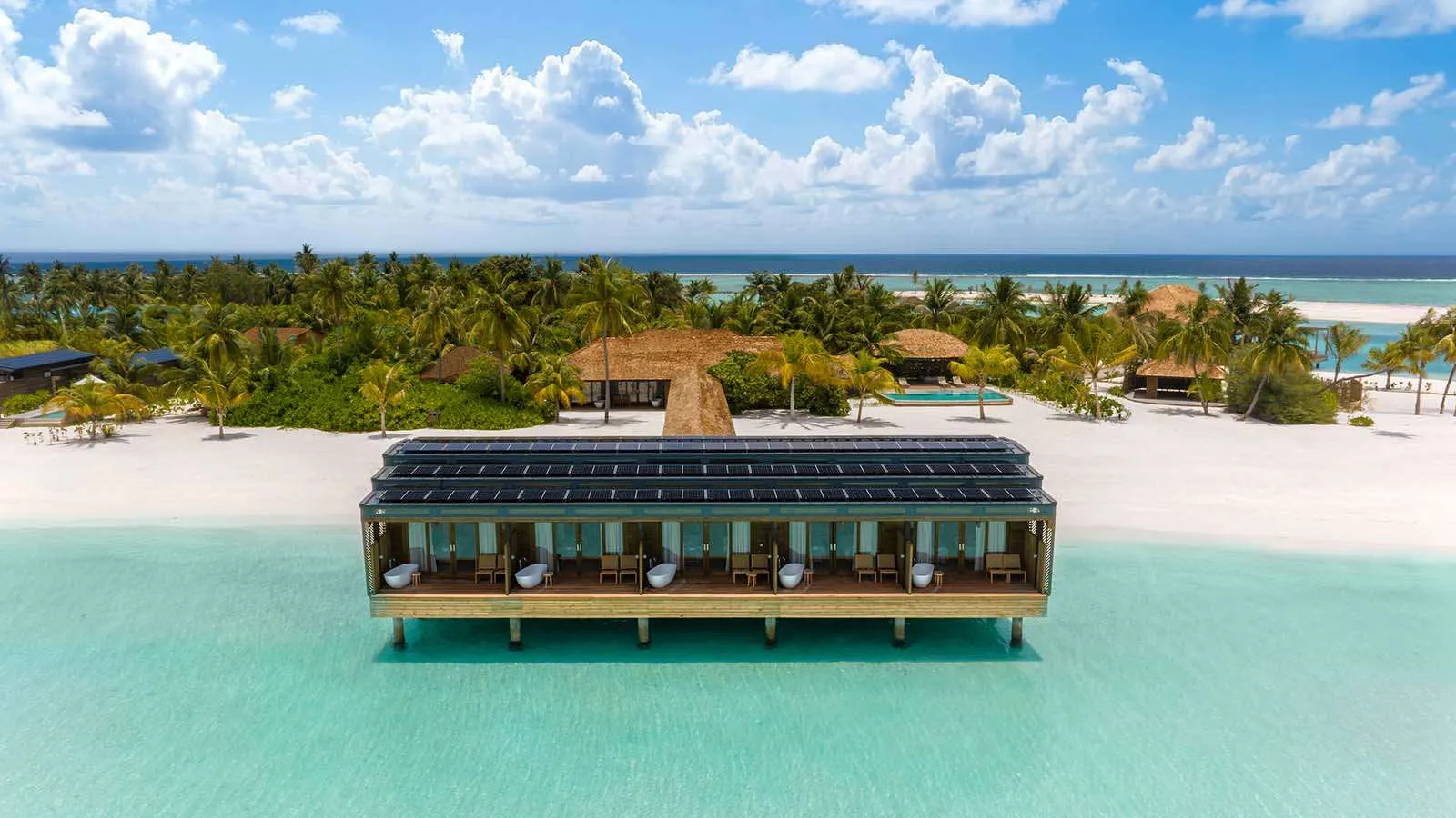 La Sulha Spa costruita sull’acqua, davanti alla spiaggia, con i pannelli solari sul tetto e le palme dietro.