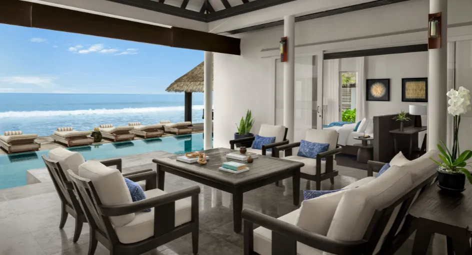 The Two Bedroom Beach Pool Residence living room, open to the pool, the loungers and the ocean.