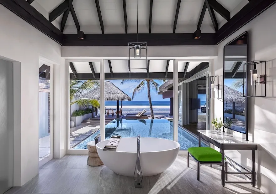 The Jo Loves House bathroom: the freestanding bath before the glass, the pool and the pavilion facing the ocean.