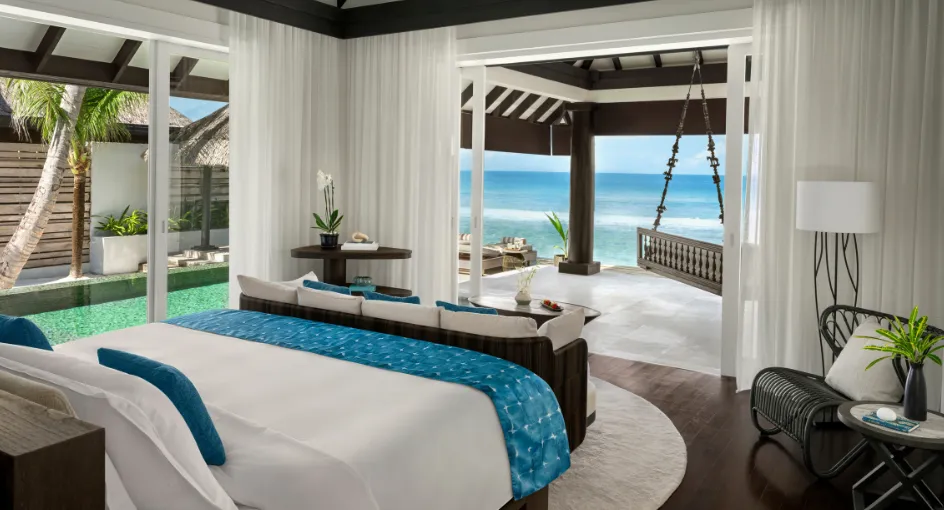An Ocean House bedroom: the bed facing the glass, the pool and the pavilion with its swing above the ocean.