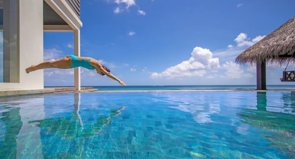 A dive into the Two Bedroom Beach Pool Residence’s 12 m infinity pool, the thatched pavilion at its edge.