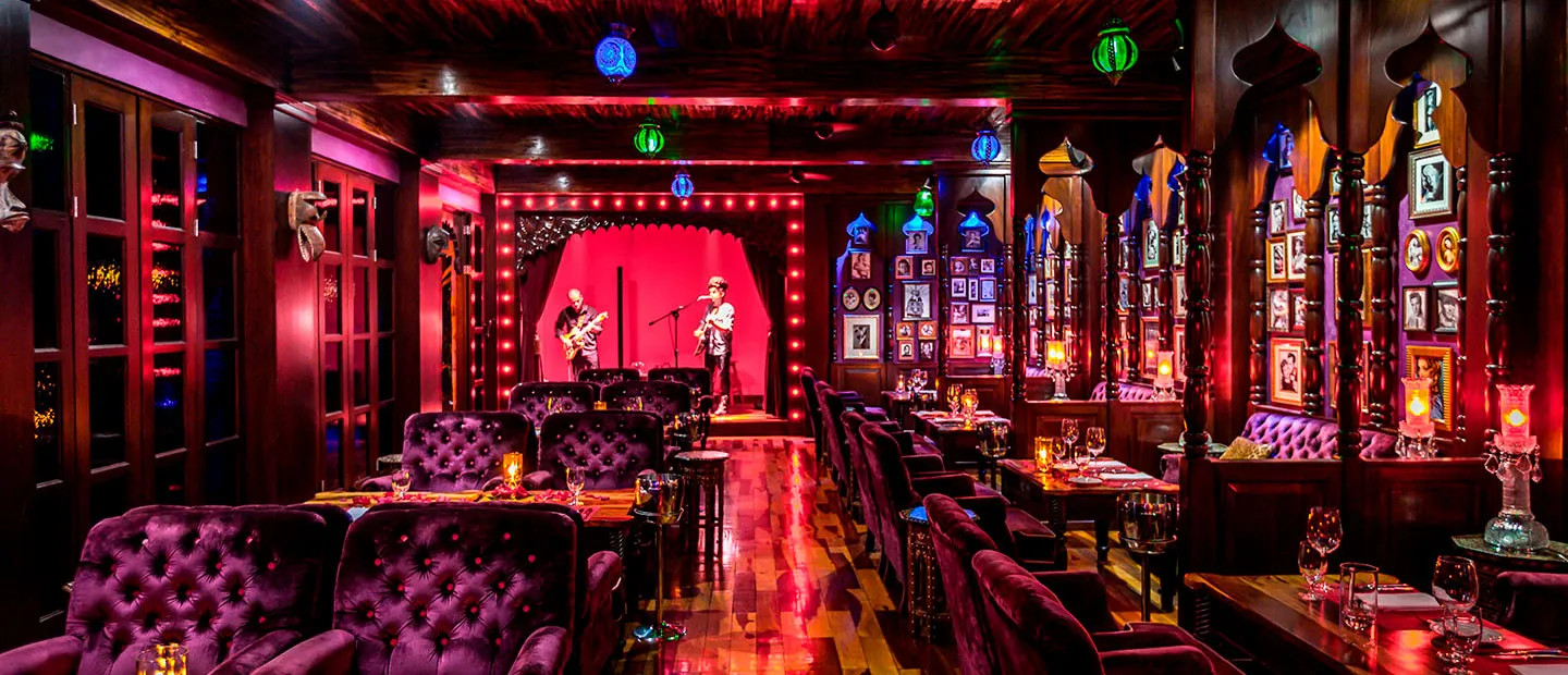 Amor Loco’s dining room, with purple armchairs, mirrors and red lights