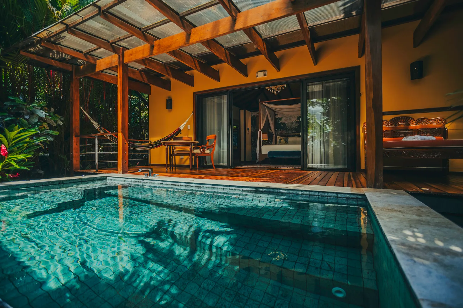 The private pool in front of the covered terrace, with the four-poster bed behind