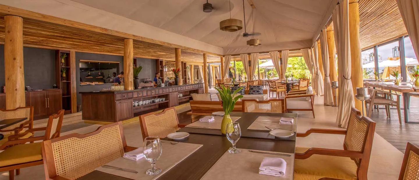 Ayla’s dining room, with woven chairs and tables laid for a meal