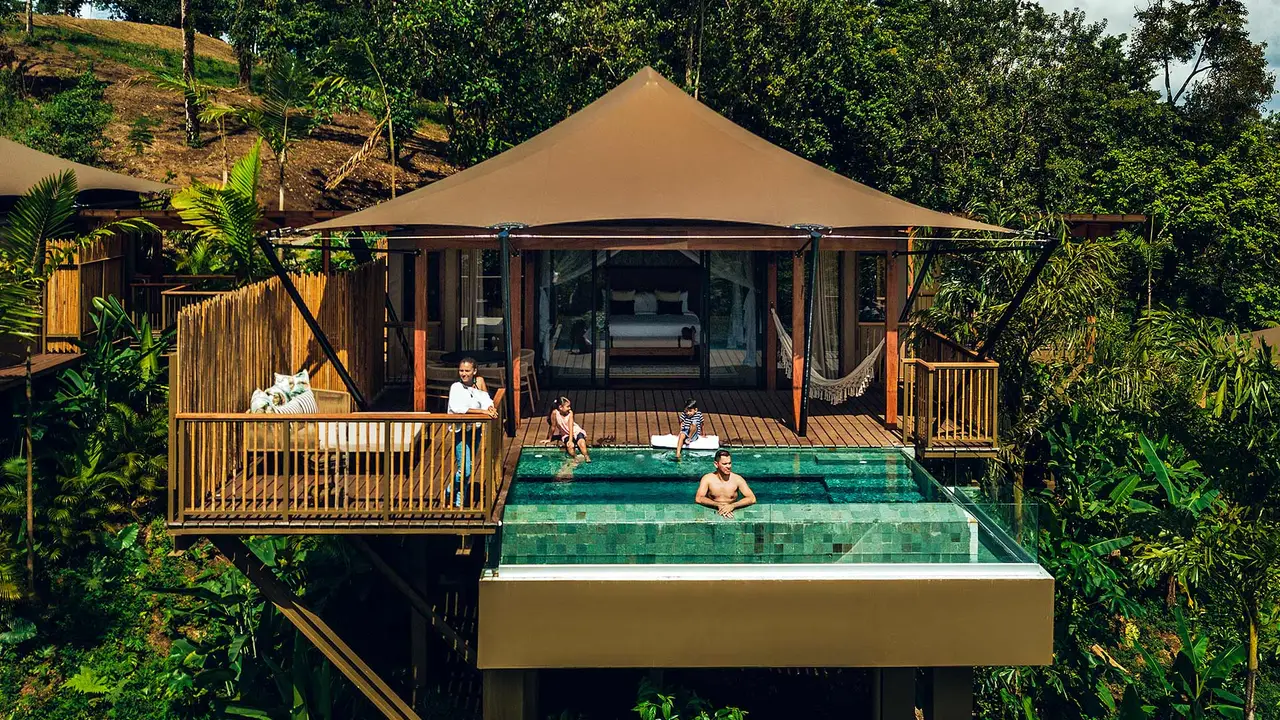 A tent with people on the terrace and in the private pool