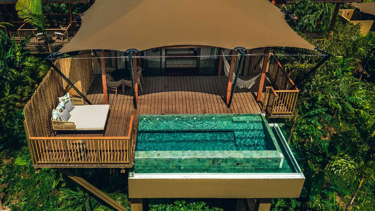 A tent seen from above, with a terrace, hammock and private pool