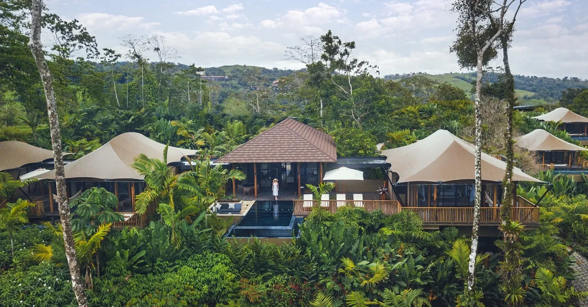 A Residence with a central pavilion and tents beside the pool