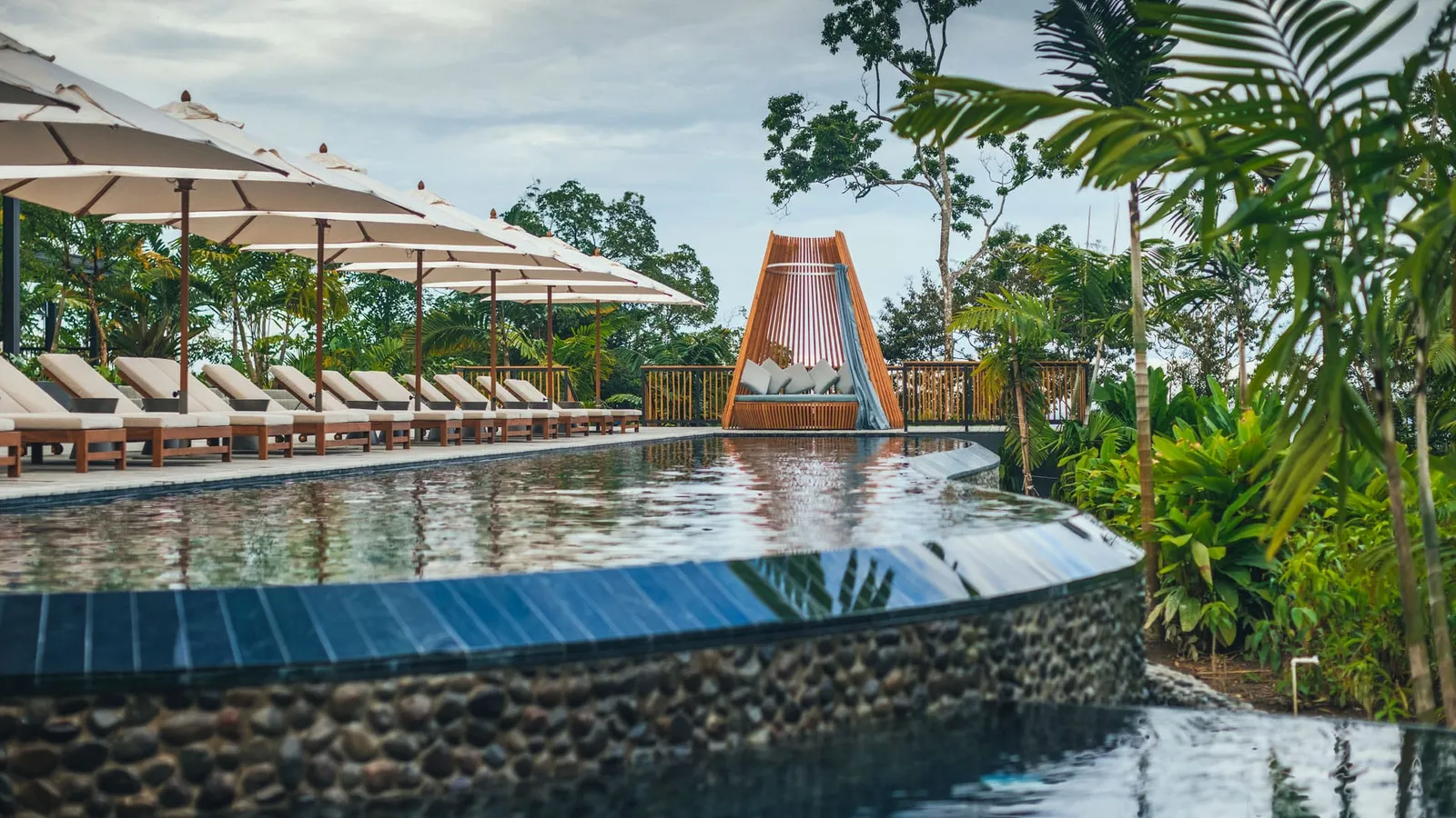 The main pool with loungers and umbrellas among tropical plants