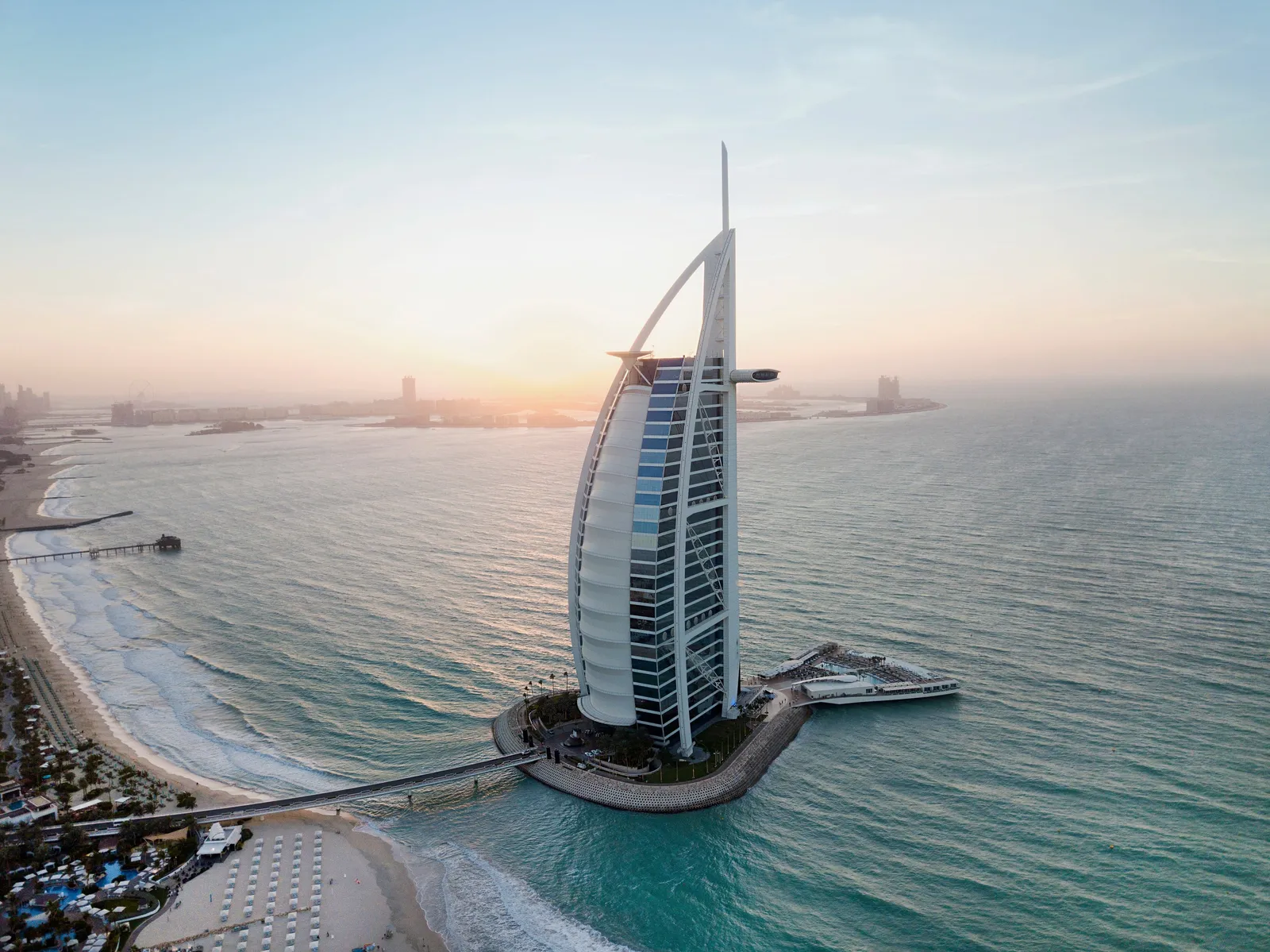 Il Burj Al Arab dall’alto al tramonto, sulla sua isola, con il ponte e la spiaggia di Jumeirah sotto