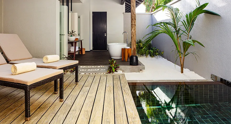 The courtyard of a villa with a private pool: loungers on the deck, the plunge pool and the open-air bathtub.
