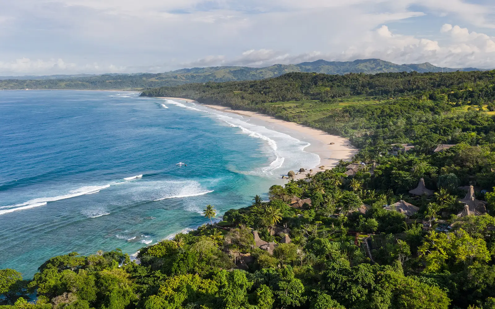 La baia di Nihiwatu dall’alto: la spiaggia bianca, le onde e i tetti delle ville fra il verde