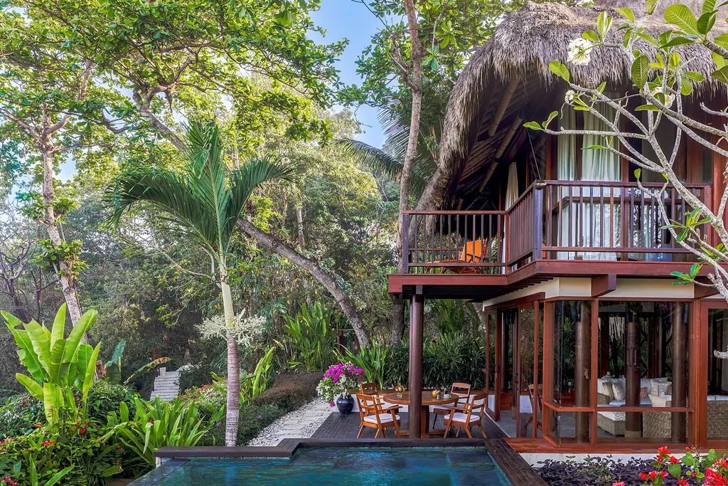 Kanatar fra gli alberi: la casa di legno su 2 piani con il tetto di paglia, il balcone e la piscina ai piedi