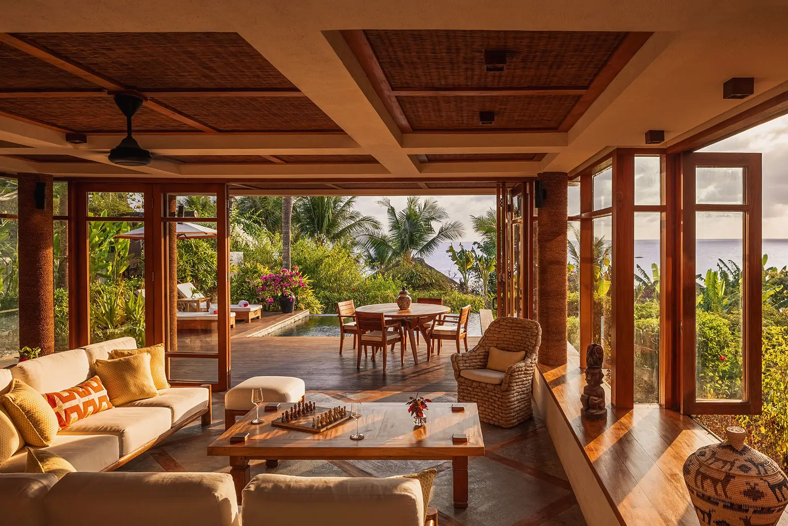 Il soggiorno di Mandaka Sumba House: divani, soffitto di legno e le vetrate aperte sul giardino